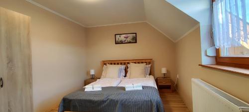 1 dormitorio con cama y ventana en Andika Apartman Szajk en Szajk