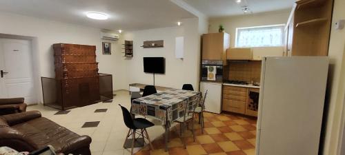 a living room with a table and a kitchen at Andika Apartman Szajk in Szajk