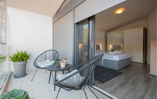Pokój z balkonem z łóżkiem i stołem w obiekcie Gorgeous Home In Vrgorac With Outdoor Swimming Pool w mieście Vrgorac