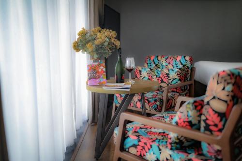 a table with a vase of flowers and two chairs at K House Apartment Danang Beach in Da Nang