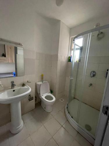 a bathroom with a toilet and a sink and a shower at One Bedrooms & Studios at Ngong Rd in Nairobi