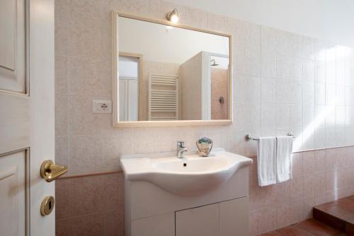 a bathroom with a white sink and a mirror at Ombra Verde Residence e B&B in Follonica