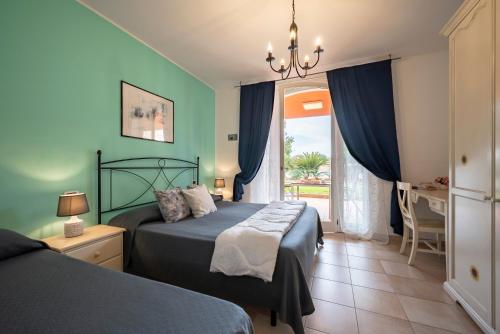 Ombra Verde Residence e B&B في فولونيكا: غرفة نوم بسريرين ونافذة