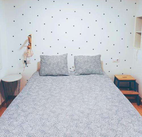 1 dormitorio con 1 cama grande y 2 almohadas en Apartamento Bonhomía, en A Coruña