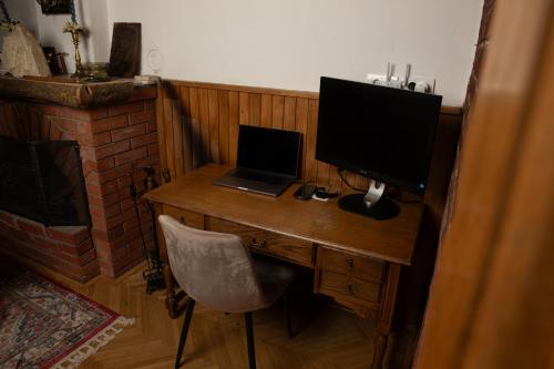 a desk with a laptop and a computer monitor on it at Tarushka house in Rača