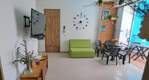 uma sala de estar com uma cadeira verde e um relógio na parede em Condominio Paraíso del Sol em San Jerónimo