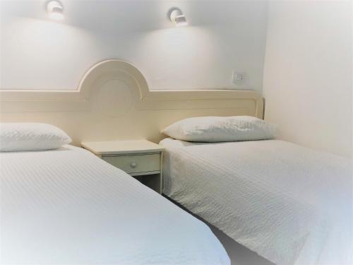 two beds in a small room with white walls at Acapulco Ocean View in San Agustin