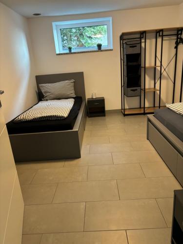 1 dormitorio con 1 cama y suelo de baldosa en Ferienwohnung Annashome, en Maxhütte-Haidhof