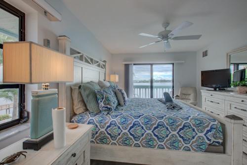 a bedroom with a bed and a television in it at Anna Maria Island Beach Palms 2B in Bradenton Beach