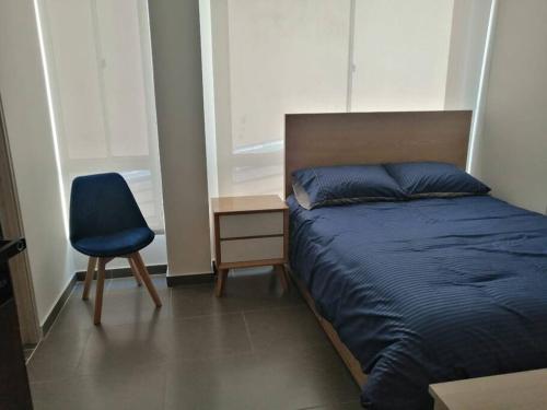 1 dormitorio con 1 cama y 1 silla azul en Bien ubicado, cómodo y funcional, en Bogotá