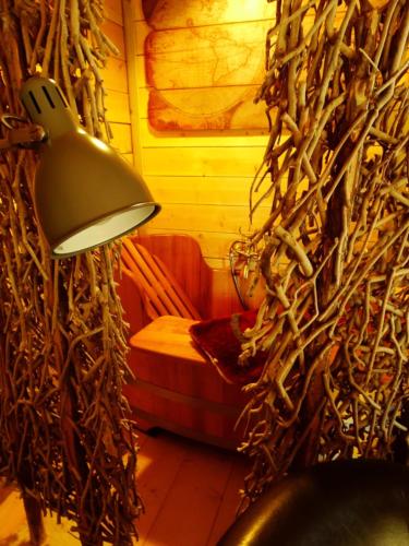a lamp in a room with a wall of branches at Etangs du Moulin in Suzy
