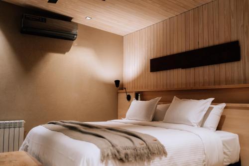 1 dormitorio con 1 cama grande con almohadas blancas en Andeluna Winery Lodge en Tupungato