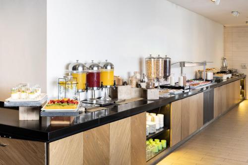 a buffet line with food on display in a restaurant at Holiday Inn Santiago - Airport Terminal by IHG in Santiago