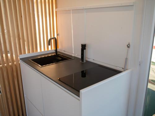 a small kitchen with a sink in a cabinet at La Maison de la Mer Sotogrande in Sotogrande