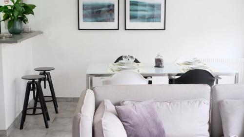 ein Wohnzimmer mit einem weißen Sofa und einem Tisch in der Unterkunft Une pause à Evreux logement entier in Évreux
