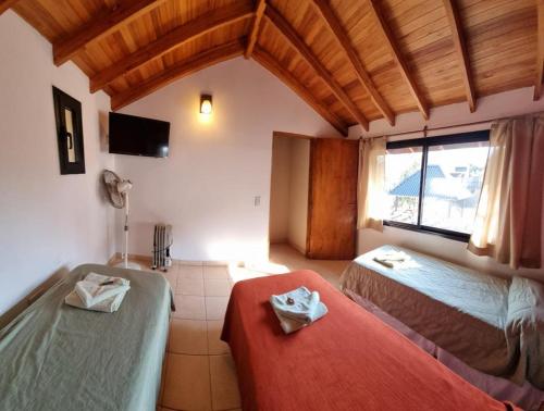 a room with two beds and a television in it at Complejo del Jaguel in Santa Teresita