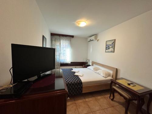 a room with a bed and a flat screen tv at Beatrix Lux Hotel in Budva
