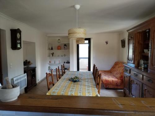una sala da pranzo con tavolo e divano di Maison familiale de vacances a Serres