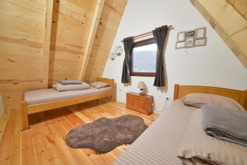 a bedroom with two beds and a window at Lux Villas Zabljak in Žabljak