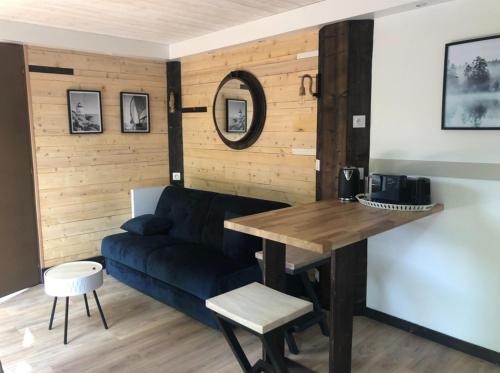 un salon avec un canapé bleu et une table dans l'établissement La cabane du pêcheur - Lodges de Bonfruit, à Pompierre