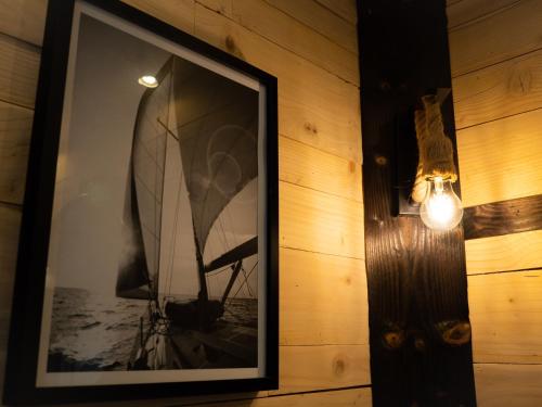 ein gerahmtes Bild eines Bootes an einer Wand in der Unterkunft La cabane du pêcheur - Lodges de Bonfruit 