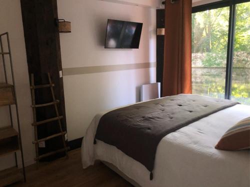 ein Schlafzimmer mit einem großen Bett und einem Fenster in der Unterkunft La cabane du pêcheur - Lodges de Bonfruit 