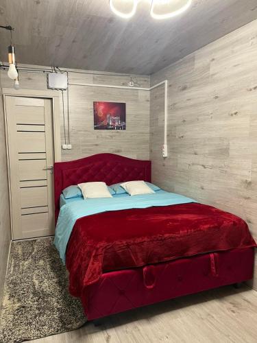 um quarto com uma grande cama vermelha em Sunny apartments em Chisinau