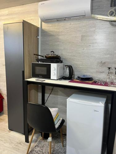 uma cozinha com uma mesa, um micro-ondas e uma cadeira em Sunny apartments em Chisinau