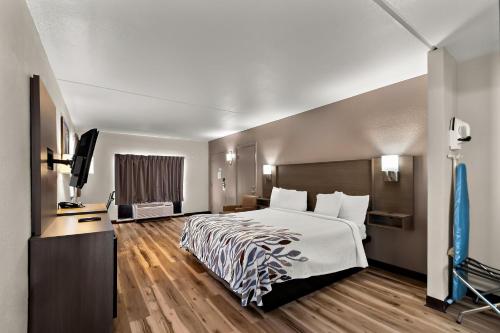 a hotel room with a bed and a flat screen tv at Red Roof Inn Winchester, VA in Winchester