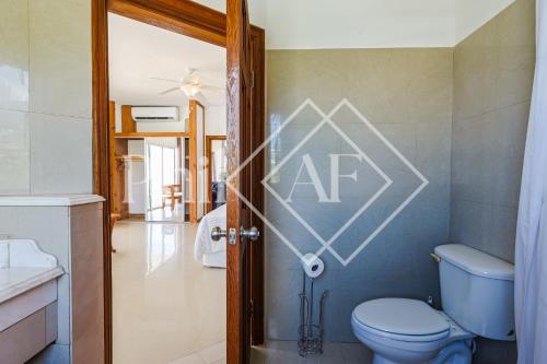 W pokoju znajduje się łazienka z niebieską toaletą. w obiekcie 10 bed-rooms luxury BEACH VILLA w mieście Guana Bay