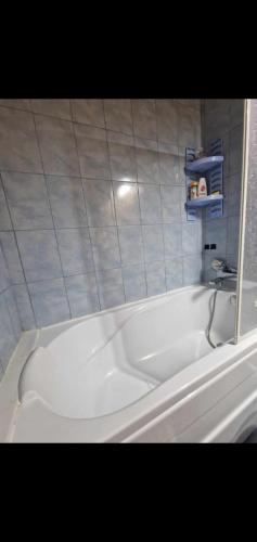 a white bath tub in a bathroom with a tile wall at Ap Central Traian Moșoiu 2 Parcare proprie in Cluj-Napoca