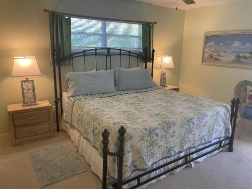 a bedroom with a bed and two lamps and a window at Escape to an island adventure! Free bikes & beach items in Anna Maria