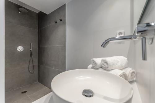 a bathroom with a white sink and a shower at Lianos Village in Agios Prokopios