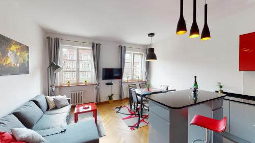 弗罗茨瓦夫Rynek Market Square Wroclove Tectum Apartments z widokiem na Rynek的客厅里有一张沙发和一张桌子。
