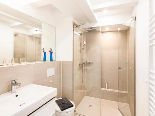 La salle de bains est pourvue d'une douche et d'un lavabo. dans l'établissement FeWo Prora - Strandjuwel, à Binz