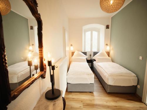 una camera con due letti e uno specchio di Gästehaus im Schlosspark 