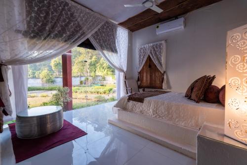 um quarto com uma cama e uma grande janela em Shalom Corbett’s Hillside Hideaway em Belparāo