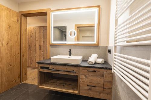 a bathroom with a sink and a mirror at Grubi´s Chalet Alm in Gerlos