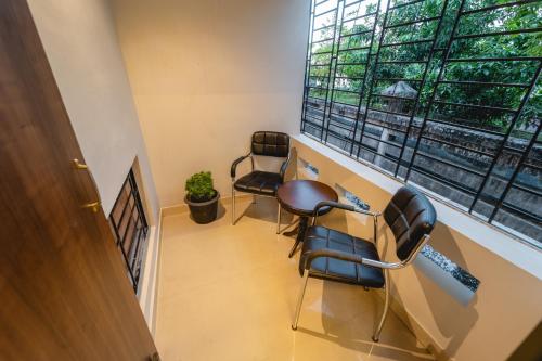 a room with two chairs and a desk and a window at Alhanney Housing in Guwahati