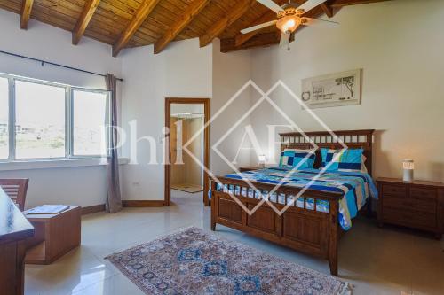 a bedroom with a bed and a ceiling fan at 10 bed-rooms luxury BEACH VILLA in Guana Bay