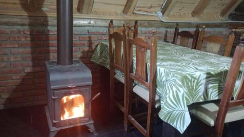 a wood stove in a room with a bed at Cabañas sarai in Perito Moreno