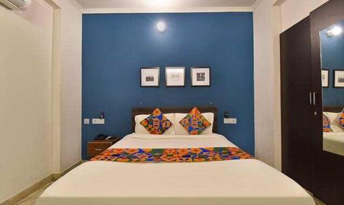 a bedroom with a large bed with a blue wall at FabHotel Gangashrey in Jaipur