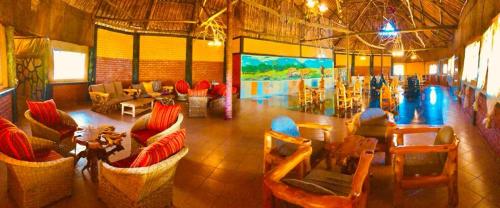 a large room with couches and chairs and a table at Eco Mara Tented Camp in Ololaimutiek