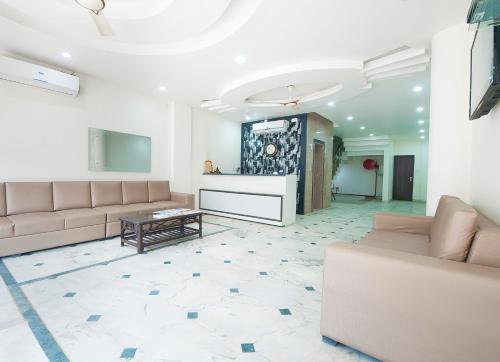 a living room with couches and a table at Hotel Jiva Banquet in New Delhi