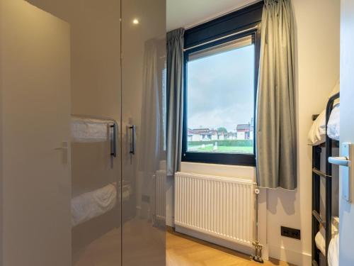 Zevenhuizen的住宿－Holiday home in South Holland with shared pool，一间带玻璃淋浴和窗户的浴室