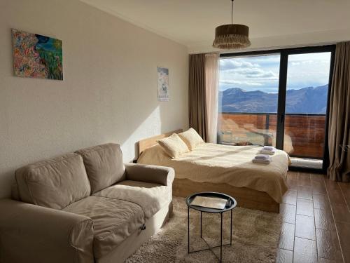 ein Wohnzimmer mit einem Sofa und einem Bett in der Unterkunft Twins #144 New Gudauri with Mountain View in Gudauri