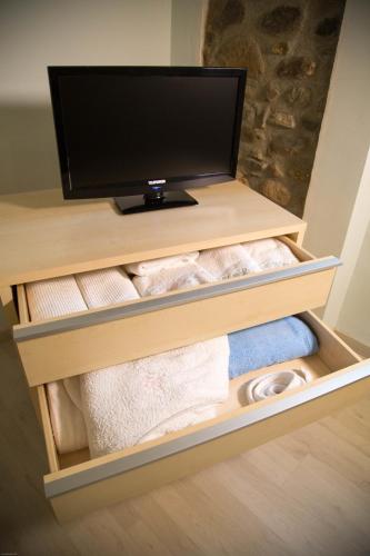 a tv sitting on top of a shelf with towels at Residenza il Gelsomino in Cantello