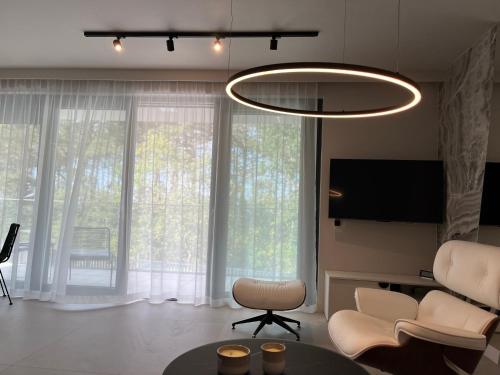 ポゴジェリツァにあるSea View Pogorzelica Szeroka Spokojna Plaża z widokiem na morzeのリビングルーム(シャンデリア、テーブル、椅子付)