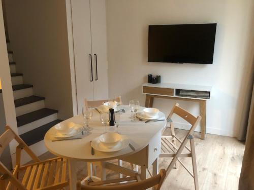 une salle à manger avec une table avec des chaises et une télévision dans l'établissement Maisonnette au cœur du vignoble, à Ambonnay