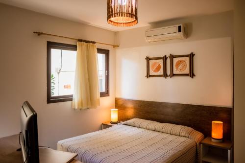 um quarto com uma cama e uma janela em Apart Hotel Serantes em Natal